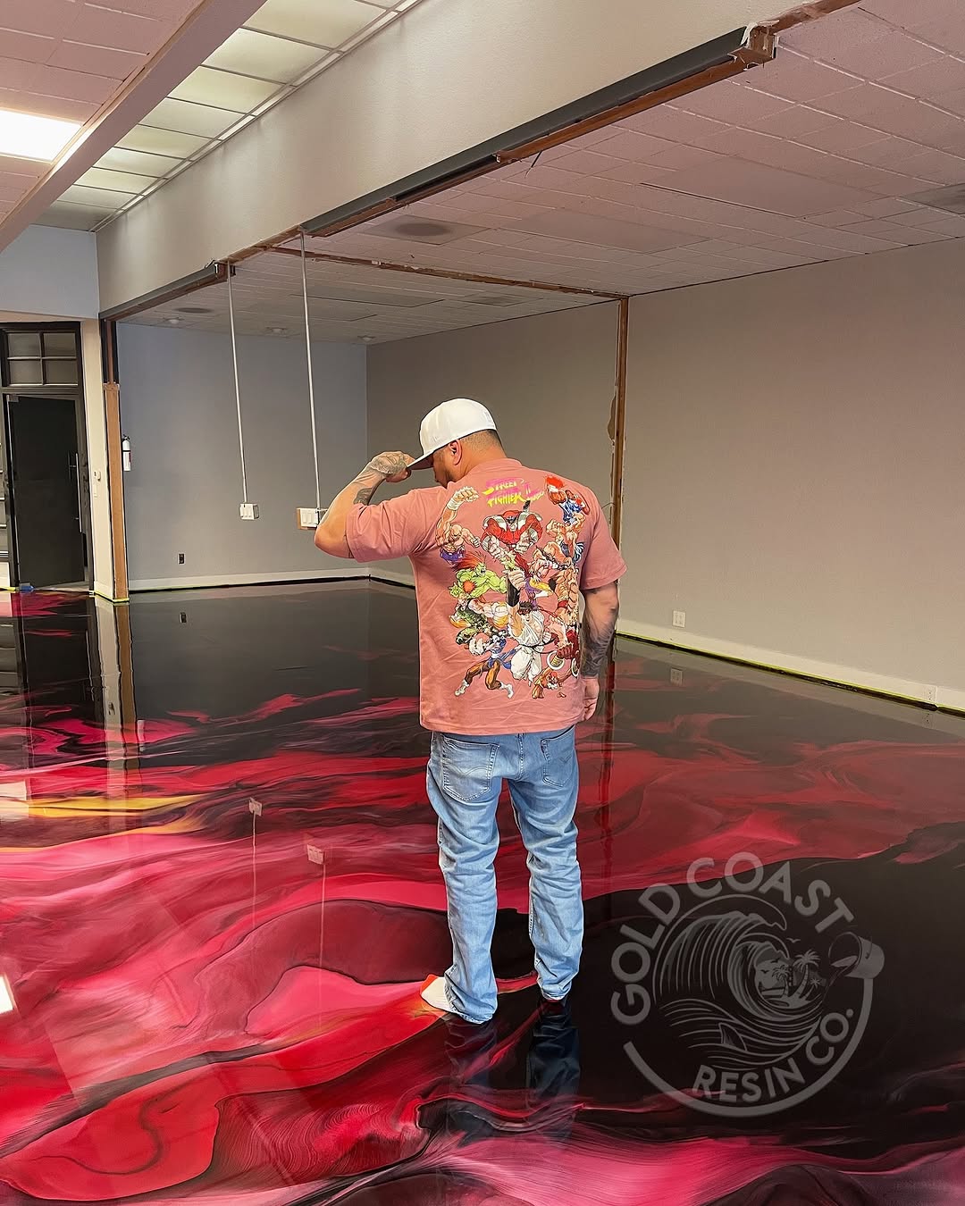 Johnny Mendoza standing on a vivid red and pink metallic epoxy floor during pour