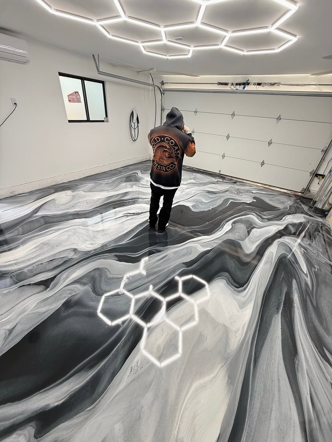 Close-up of multi-layer epoxy garage floor coating showing material thickness