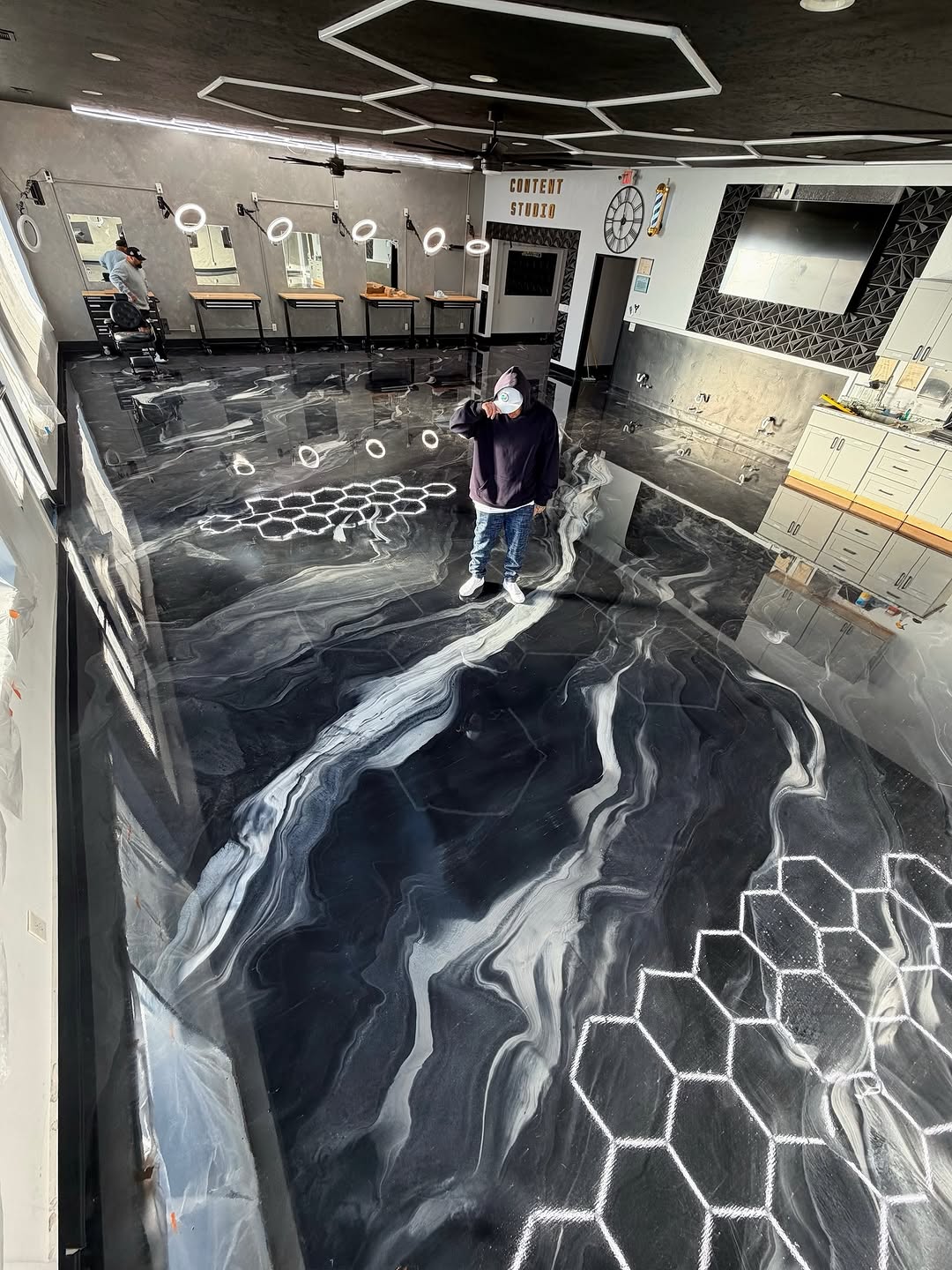 Custom metallic epoxy barbershop floor with brand logo embedded