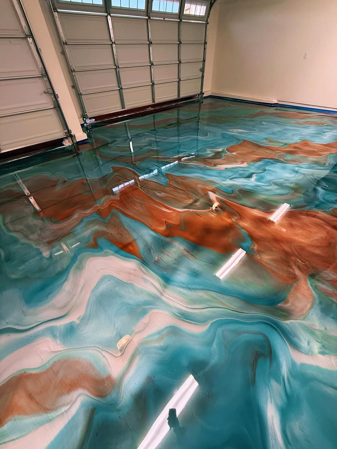 Metallic epoxy floor with flowing silver and gold patterns in a retail space