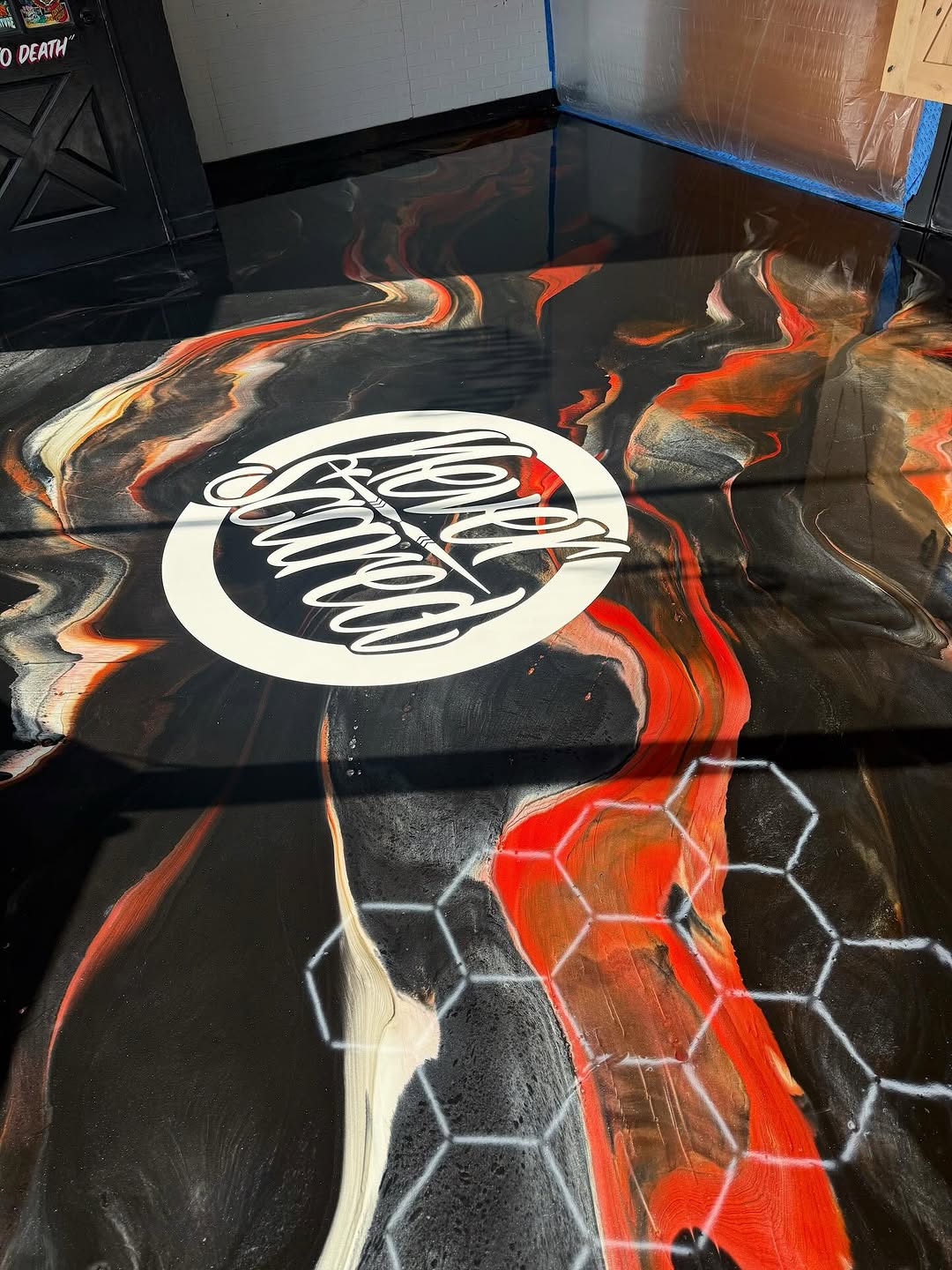 Solid color epoxy floor with integral cove base in a tattoo studio