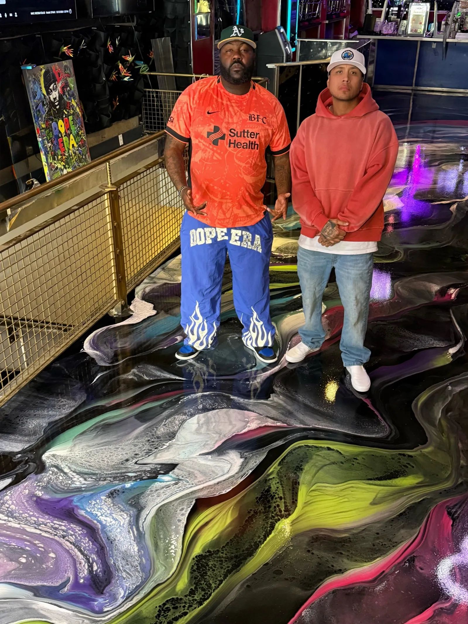 Two men standing on a multicolor marbled metallic epoxy floor installed by Gold Coast Resin